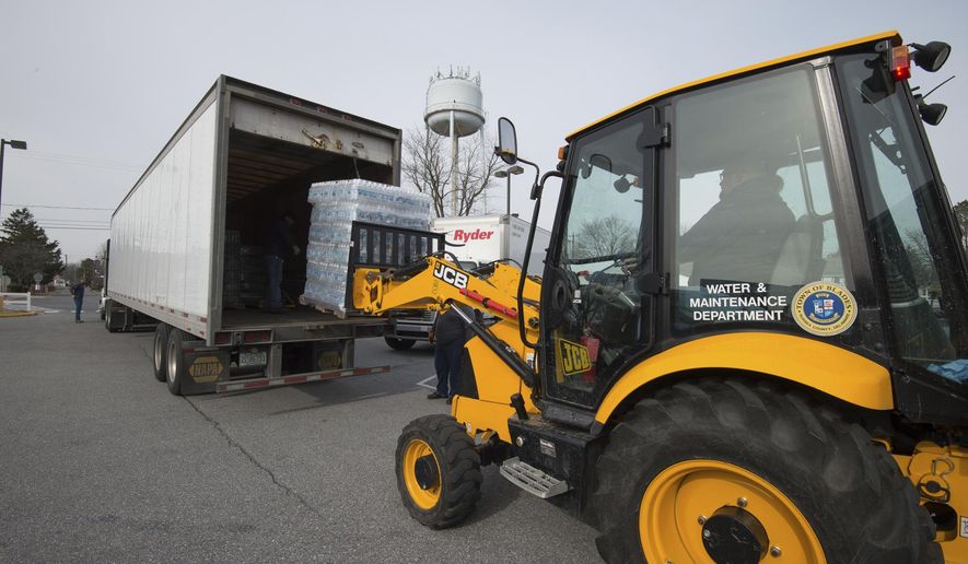 Pallets of drinking water are uploaded at Blades Elementary School, Friday, Feb. 9, 2018, in Blades. Del. State environmental and public health officials announced late Thursday that sampling done at the request of the Environmental Protection Agency found that all three of the town of Blade's drinking water wells had high concentrations of perfluorinated compounds. (Jason Minto/The News Journal via AP)