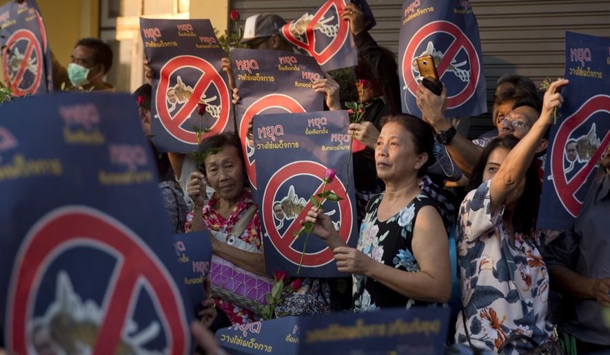 Protesters holding placards reading "Stop laying dictatorship eggs. Stop delaying an election. Stop holding on to power," during a protest near democracy monument Saturday, Feb. 10, 2018, in Bangkok, Thailand. About 200 anti-government protesters have rallied in the Thai capital Bangkok calling on the country's military rulers to give up power and hold elections they promised soon after staging a coup in 2014. (AP Photo)