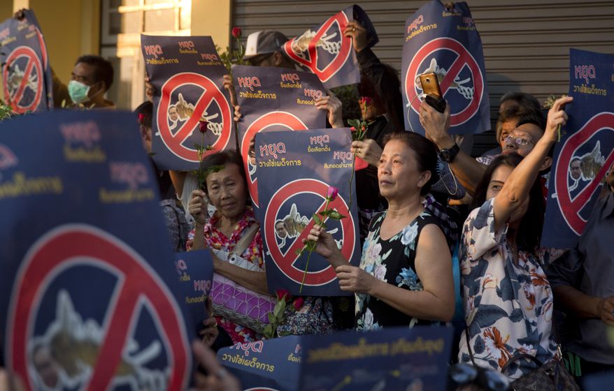 Protesters holding placards reading "Stop laying dictatorship eggs. Stop delaying an election. Stop holding on to power," during a protest near democracy monument Saturday, Feb. 10, 2018, in Bangkok, Thailand. About 200 anti-government protesters have rallied in the Thai capital Bangkok calling on the country's military rulers to give up power and hold elections they promised soon after staging a coup in 2014. (AP Photo)