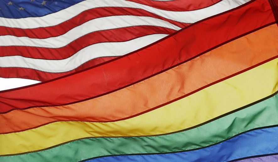 The Rainbow Flag flies beneath the American flag. (AP Photo/Mark Lennihan)