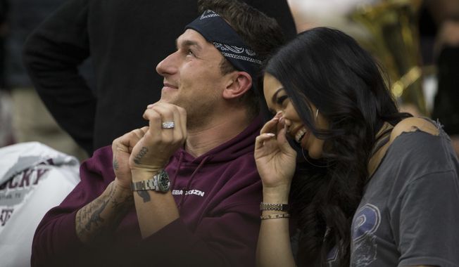 Former Texas A&amp;M quarterback Johnny Manziel sits with his fiancé Bre Tiesi during an NCAA college basketball game between Kentucky and Texas A&amp;M Saturday, Feb. 10, 2018, in College Station, Texas. (AP Photo/Sam Craft)
