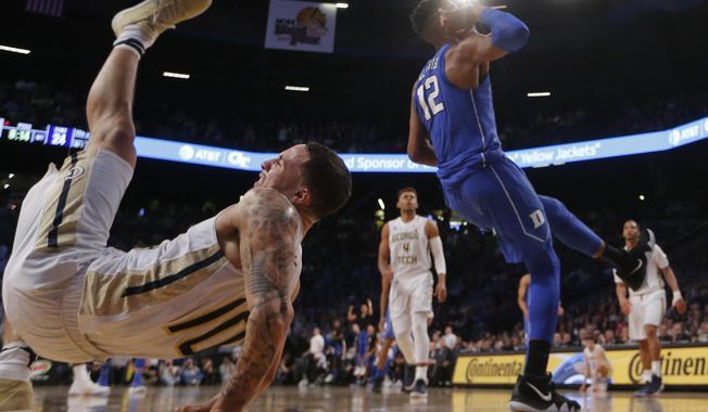 Georgia Tech guard Jose Alvarado (10) falls to the floor after battling Duke forward Javin DeLaurier (12) during an NCAA college basketball game Sunday, Feb. 11, 2018, in Atlanta. Alvarado injured his arm and left the game. (AP Photo/John Bazemore)