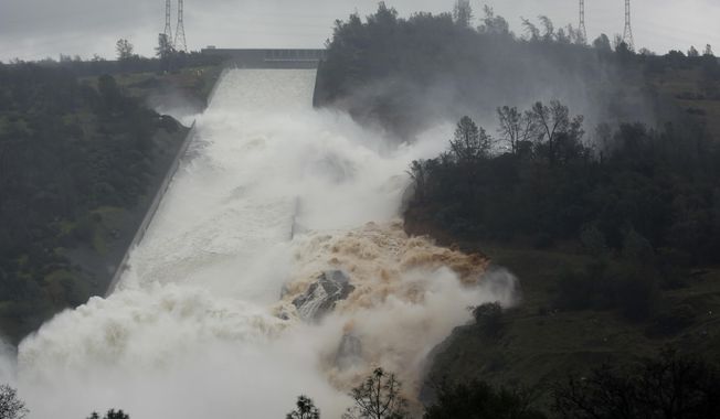 FILE - In this Feb. 9, 2017 file photo, water flows through a break in the wall of the Oroville Dam spillway in Oroville, Calif. One year after the closest thing to disaster at a major U.S. dam in a generation, federal dam regulators say they are looking hard at how they overlooked the built-in weaknesses of old dams like California&#x27;s Oroville Dam for decades, and expect dam managers around the country to study their old dams and organizations equally hard. (AP Photo/Rich Pedroncelli, file)