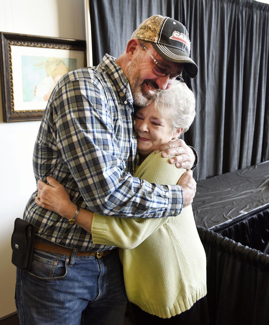 In this Wednesday, Jan. 31, 2018 photo, Judy Berry hugs Joe Hagman of Hawesville for returning her lost 1965 Owensboro High School ring to her after all these years in Owensboro, Ky. (Alan Warren/The Messenger-Inquirer via AP)