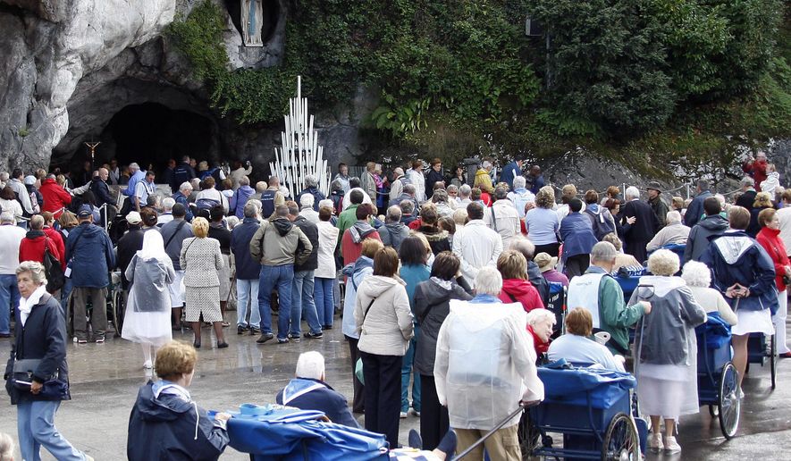 FILE - In this Sept. 12, 2008, file photo, pilgrims queue to visit the grotto at Lourdes, southwestern France. A French bishop on Sunday, Feb. 11, 2018, declared as a miracle the cure of a Roman Catholic nun who was an invalid for nearly four decades and recovered after making a pilgrimage to Lourdes. Bishop Jacques Benoit-Gonin of the Beauvais diocese north of Paris proclaimed the miracle 10 years after Bernadette Moriau, now 79, went to Lourdes. (AP Photo/Bob Edme, File)