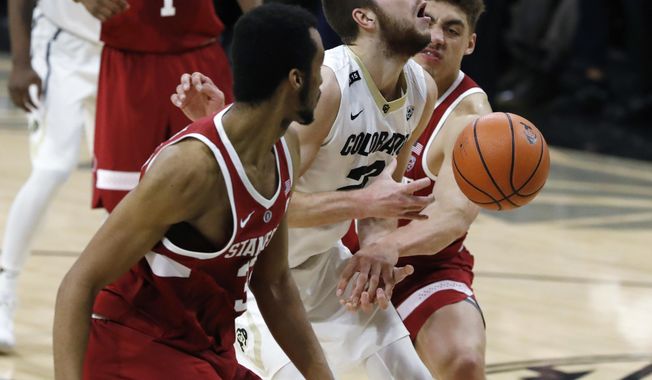 Colorado forward Lucas Siewert, center, is fouled as he goes up for a basket between Stanford forwards Trevor Stanback, front, and Reid Travis in the second half of an NCAA college basketball game Sunday, Feb. 11, 2018, in Boulder, Colo. Colorado won 64-56. (AP Photo/David Zalubowski)
