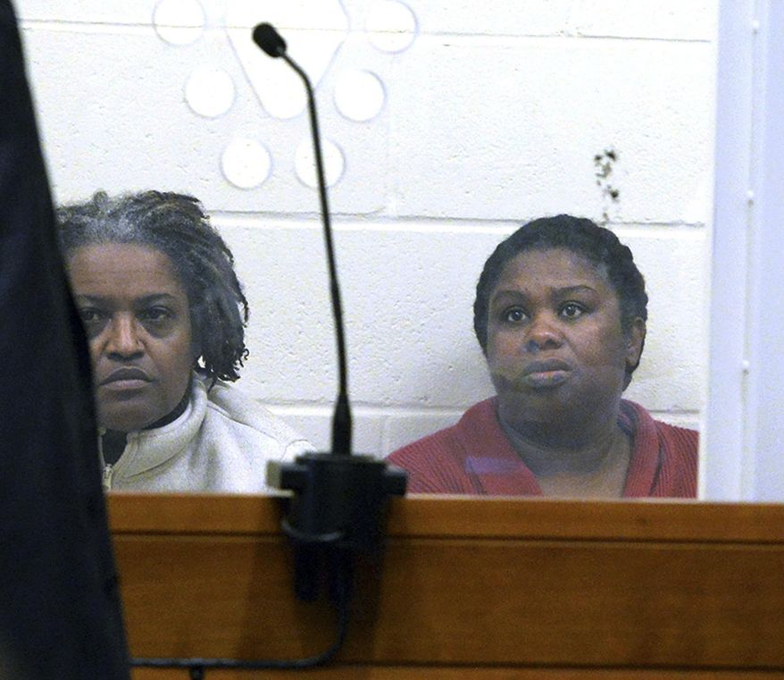 FILE - In this Feb. 1, 2018 file photo, sisters Rachel Hilaire and Peggy LaBossiere sit in Brockton District Court in Bridgewater, Mass., charged with tying down and burning a 5-year-old girl, permanently disfiguring her, in a voodoo ritual meant to rid her of a demon causing her to misbehave, police said. But practitioners of Haitian Vodou said the religion doesn't sanction violence and fear the incidents will spark a backlash against their community. (Marc Vasconcellos/Enterprisenews.com via AP, Pool, File)