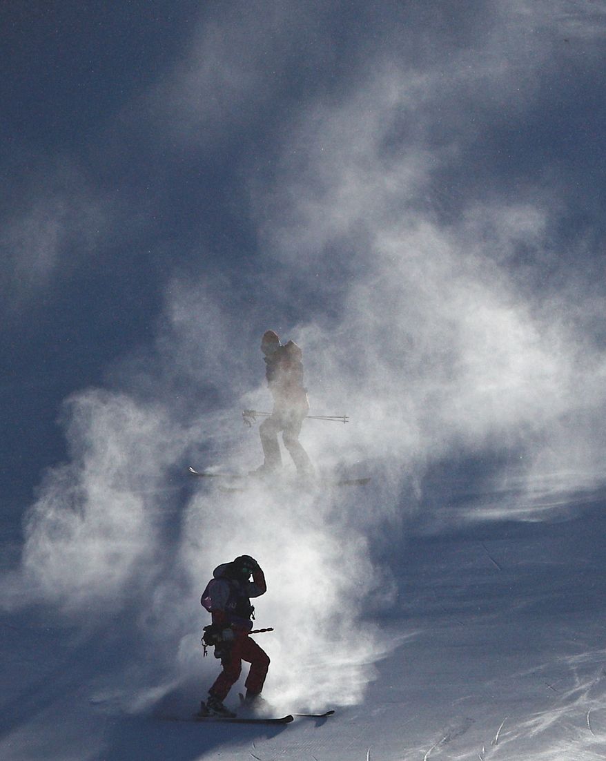 Course crew are shrouded in snow after the women's giant slalom was postponed due to high winds on Monday. (ASSOCIATED PRESS)