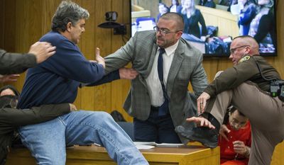 Randall Margraves, left, father of three victims of Larry Nassar, background right, lunges at Nassar in Eaton County Circuit Court in Charlotte, Mich., on Friday, Feb. 2, 2018. The incident came during the third and final sentencing hearing for Nassar on sexual abuse charges. The charges in this case focus on his work with Twistars, an elite Michigan gymnastics club. (Cory Morse/The Grand Rapids Press via AP)
