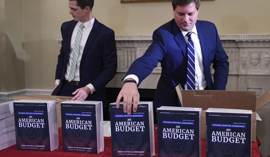 James Knable, left, and Jeffrey Freeland, right, help to unpack copies of the President's FY19 Budget after it arrived at the House Budget Committee office on Capitol Hill in Washington, Monday, Feb. 12, 2018. (AP Photo/Susan Walsh)