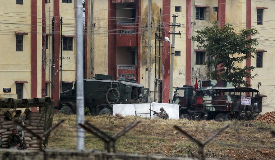 An Indian Army soldier takes position after surrounding the residential quarters where militants are believed to be holed up in an Army camp in Jammu, India, Sunday, Feb.11, 2018. At least two soldiers were killed and three others wounded in Indian-controlled Kashmir on Saturday as soldiers traded fire with armed militants who were holed up inside an army camp, officials said. (AP Photo/Channi Anand)
