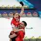 Canadians Kaitlyn Lawes and John Morris celebrate after winning the gold medal against Switzerland in the debut of mixed doubles curling on Tuesday.