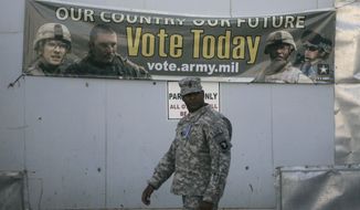 A U.S member of Combined Joint Task Force-101 walks past an election banner at a US military base in Bagram north of Kabul, Afghanistan, Wednesday, Oct. 15, 2008.  Soldiers, aid workers and military contractors in Afghanistan are filling out absentee ballots this week and sending them back to the states in hopes they arrive in time to be counted by elections officials. (AP Photo/Rafiq Maqbool)