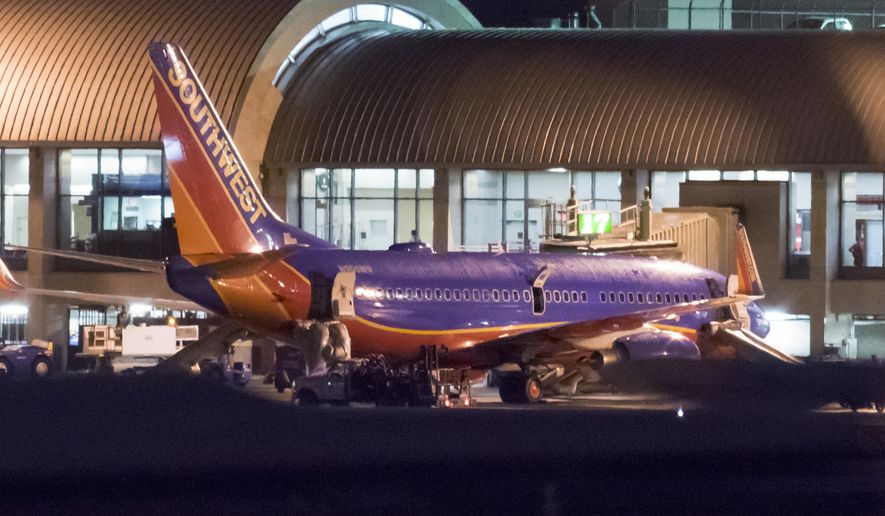 In this Monday, Feb. 12, 2018 photo, a Southwest Airlines plane sits it a gate after passengers had to evacuate before takeoff because of a fire at John Wayne Airport in Santa Ana, Calif. Federal Aviation Administration spokesman Allen Kenitzer says the blaze was in the airliner&#x27;s auxiliary power unit and was extinguished with the plane&#x27;s fire suppression system (Leonard Ortiz/The Orange County Register via AP)