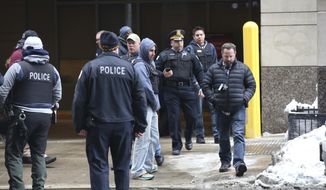 Chicago Police officers arrive at Northwestern Memorial Hospital emergency room, where an high-ranking Chicago Police officer was brought in code red, serious to critical condition, after being shot in or near the Thompson Center in Chicago, Tuesday, Feb. 13, 2018. Spokesman Anthony Guglielmi says the off-duty officer was shot around 2 p.m. Tuesday at the James R. Thompson Center. Guglielmi says the preliminary information is that the shooting happened just outside the building. The officer was transported to Northwestern Memorial Hospital. (John J. Kim/Chicago Tribune via AP)