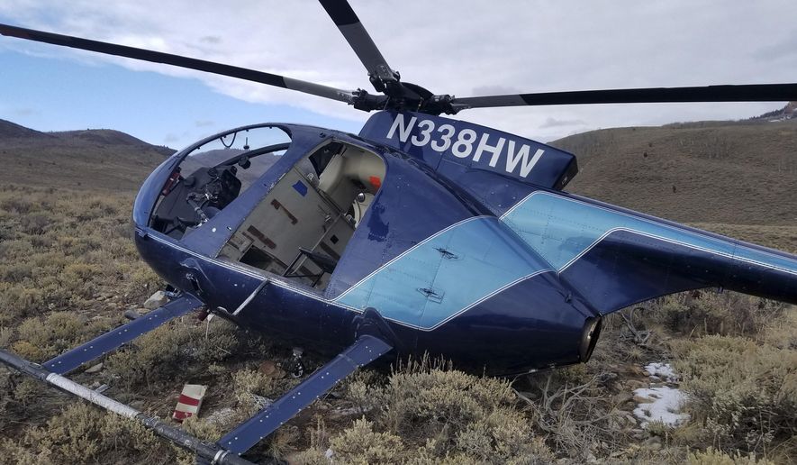 In this photo taken Monday, Feb. 12, 2018, and provided by the Wasatch County Sheriff's Office is a research helicopter that was brought down by a leaping elk in the mountains of eastern Utah. Wasatch County authorities say the elk jumped into the chopper's tail rotor as the craft flew low, trying to capture the animal with a net. The two people on board weren't seriously hurt, but wildlife officials say the elk died of its injuries. The state-contracted Australian crew had been trying to capture and sedate the elk so they could collar it and research its movements about 90 miles east of Salt Lake City. (Jared Rigby/Wasatch County Sheriff's Office via AP)
