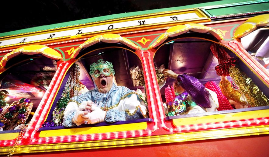 Float riders encourage the crowd as the Krewe of Orpheus rolls in New Orleans, Monday, Feb. 12, 2018. (AP Photo/Gerald Herbert)