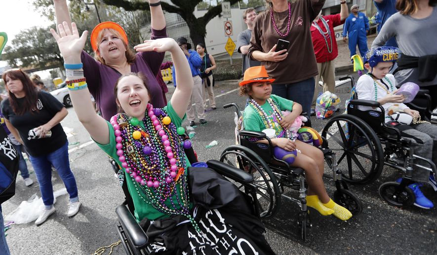 Patients from Children&#x27;s Hospital of New Orleans wave for beads and trinkets outside the facility during the Krewe of Thoth Mardi Gras parade in New Orleans, Sunday, Feb. 11, 2018. The krewe&#x27;s original parade route was designed specifically to serve people who were unable to attend other parades in the city. The route is designed to pass in front of several extended healthcare facilities.Carnival season will culminate on Mardi Gras day this Tuesday, Feb. 13. (AP Photo/Gerald Herbert)