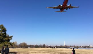 In this Jan. 26, 2018, photo, people watch a commercial passenger jet fly over Gravelly Point Park as it comes in to land at Ronald Reagan Washington National Airport in Arlington, Va., across the Potomac River from the nation&#39;s capital. In one of Virginia’s most liberal jurisdictions, political leaders are just saying ‘no’ to a proposal in Congress to name a popular park for former first lady Nancy Reagan. Legislation passed a House committee last month to rename Gravelly Point Park, which sits on federal land adjacent to Ronald Reagan National Airport, for the former first lady. The bill’s sponsor, Georgia Republican Jody Hice, says the change “would be a fitting tribute, given its proximity to Reagan National Airport.” The proposal, though, is not supported by political leaders in Arlington County, where the park is located.  (AP Photos/Matt Barakat)