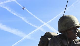 In this Friday, Feb. 9, 2018 photo, a low-flying jetliner that just took off from Phoenix Sky Harbor International Airport banks over the Navajo Code Talkers memorial at the Arizona Capitol. Last year’s court victory by Phoenix and neighborhood groups over the Federal Aviation Administration has prompted the agency to be more responsive to residents as it continues to beat back noise complaints around the United States over the air traffic modernization plan known as “NextGen.” (AP Photo/Bob Christie)