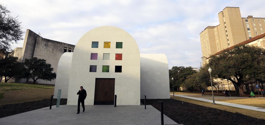 In this Monday, Feb. 12, 2018, photo, a man passes Ellsworth Kelly's "Austin" at the Blanton Museum of Art, in Austin, Texas. The exhibit, a 2,715-square-foot stone building with luminous colored glass windows is set to open to the public Sunday. (AP Photo/Eric Gay)