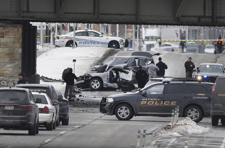 Detroit police investigators work at the scene of a crash at Clark Street and Michigan Avenue in Detroit Tuesday, Feb. 13, 2018. Detroit police officer Darren Weathers, 25, died in the crash. He was alone in the car and was involved in a training exercise, Chief James Craig said. The cause of the crash is still under investigation. (Max Ortiz/Detroit News via AP)