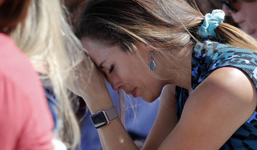 A woman cries as she bows her head in prayer during a vigil at the Parkland Baptist Church, for the victims of the Wednesday shooting at Marjory Stoneman Douglas High School, in Parkland, Fla., Thursday, Feb. 15, 2018. Nikolas Cruz, a former student, was charged with 17 counts of premeditated murder on Thursday. (AP Photo/Gerald Herbert)