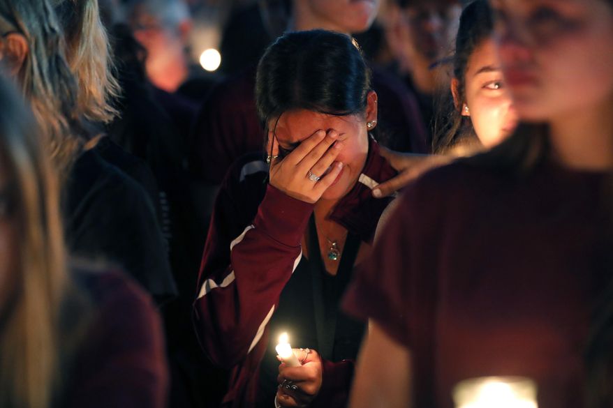 A woman cries during a candlelight vigil for the victims of the Wednesday shooting at Marjory Stoneman Douglas High School, in Parkland, Fla., Thursday, Feb. 15, 2018. Nikolas Cruz, a former student, was charged with 17 counts of premeditated murder on Thursday. (AP Photo/Gerald Herbert)