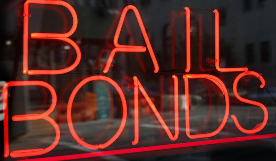 FILE - This July 7, 2015, file photo, shows a sign advertising a bail bonds business in the Brooklyn borough of New York. A new Texas nonprofit promoting crime victims’ rights is opposing bipartisan efforts to end cash bail systems that have gained traction around the country - hitting back at one of the few issues that unified advocates on both the right and left. Kicking off Thursday, Feb. 15, 2018, the Texas Alliance for Safe Communities wants to strengthen public safety and curb violent crime. (AP Photo/Kathy Willens, File)