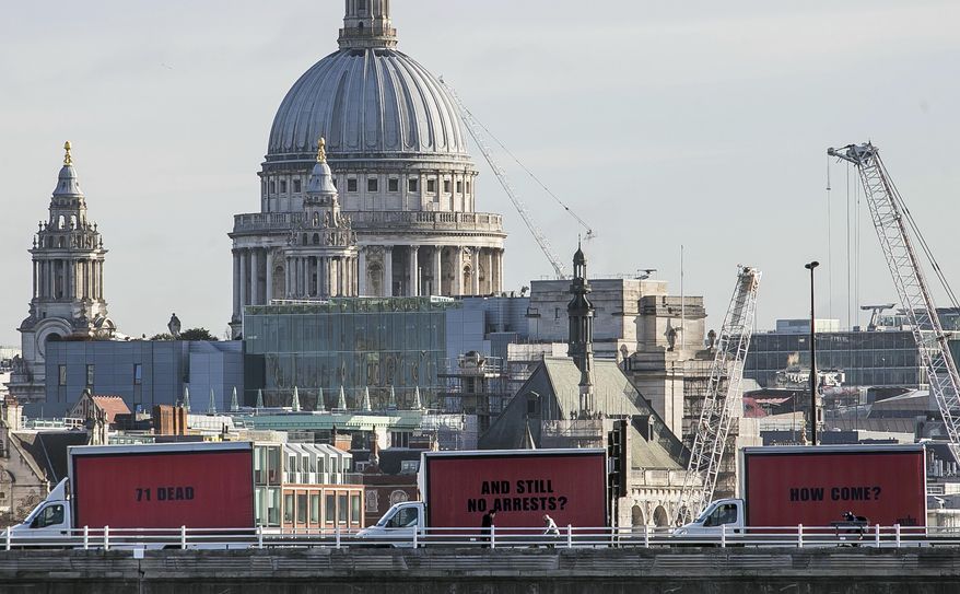 The Community-led organisation, Justice4Grenfell, parades three billboards backdropped by St. Paul's Cathedral as they move around London, Thursday Feb. 14, 2018, calling for justice for the victims of the June 14, 2017, deadly apartment fire. Campaigners for victims of the deadly London Grenfell Tower high-rise apartment fire have taken inspiration from an Academy Award-nominated film to press for more action by police. (Jeff Moore/Justice4Grenfell via AP)