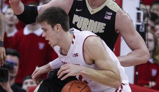 Wisconsin&#39;s Ethan Happ (22) drives on Purdue&#39;s Isaac Haas during the first half of an NCAA college basketball game Thursday, Feb. 15, 2018, in Madison, Wis. (AP Photo/Andy Manis)