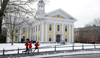 FILE - In this Jan. 14, 2016 file photo, runners make their way along a sidewalk on the campus of Wheaton College in Norton, Mass. Wheaton is getting a $10 million donation in 2018 from the Diana Davis Spencer Foundation, a conservative backer whose namesake is a Wheaton alumna. The gift will create an endowed professorship on social entrepreneurship and new space for existing programs on the topic. (AP Photo/Steven Senne, File)
