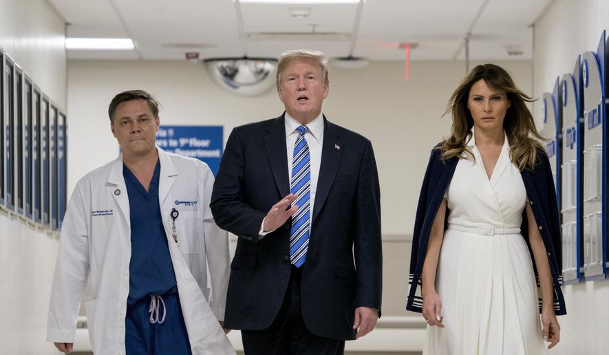 President Donald Trump, center, accompanied by and first lady Melania Trump, right, and Dr. Igor Nichiporenko, left, speak to reporters while visiting with medical staff at Broward Health North in Pompano Beach, Fla., Friday, Feb. 16, 2018, following Wednesday&#x27;s shooting at Marjory Stoneman Douglas High School, in Parkland, Fla. (AP Photo/Andrew Harnik)