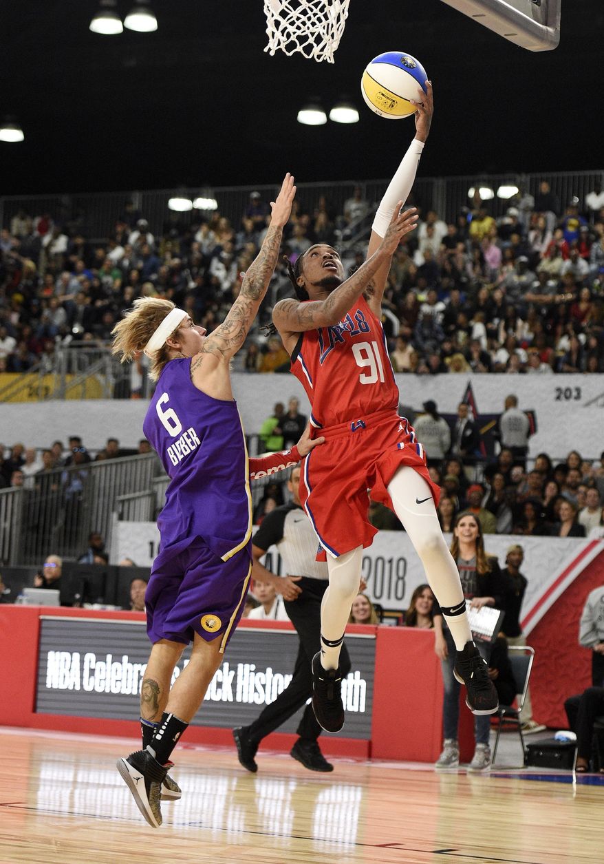 Rapper Quavo, right, of Team Clippers, shoots as singer Justin Bieber, of Team Lakers, defends during the NBA All-Star celebrity basketball game Friday, Feb. 16, 2018, in Los Angeles. (AP Photo/Chris Pizzello)