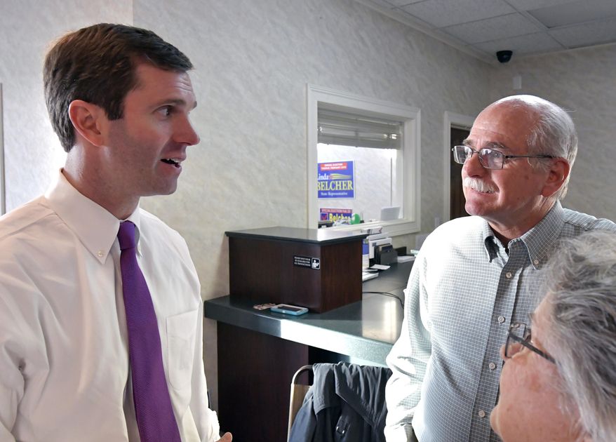 Kentucky Attorney General Andy Beshear, left, speaks with democratic supporters during a get out the vote rally, Tuesday, Feb. 13, 2018, in Shepherdsville, Ky. Democrats are competing in 93 of 100 Ky. House districts, and hope to replicate recent successes in other places that backed and elected republican candidates. (AP Photo/Timothy D. Easley)