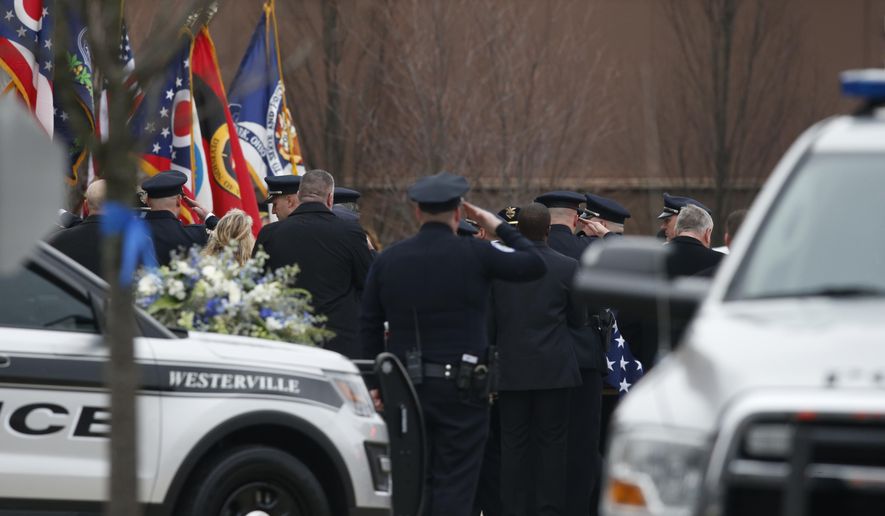 A casket is taken into St. Paul the Apostle Catholic Church in Westerville, Ohio, before the start of funeral services for Westerville police officers Anthony Morelli and Eric Joering on Friday, Feb. 16, 2018. The two veteran officers were shot after entering a residence early Saturday afternoon. (AP Photo/Paul Vernon)