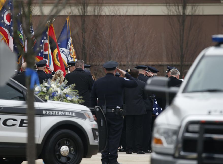 A casket is taken into St. Paul the Apostle Catholic Church in Westerville, Ohio, before the start of funeral services for Westerville police officers Anthony Morelli and Eric Joering on Friday, Feb. 16, 2018. The two veteran officers were shot after entering a residence early Saturday afternoon. (AP Photo/Paul Vernon)