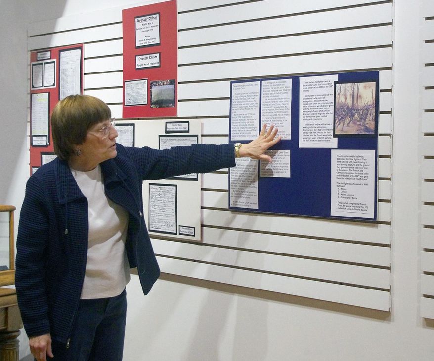 In this Feb. 2018 photo, Sherry Wesley, executive director of the South Central Kentucky Cultural Center, points to an article about the Harlem Hell Fighters in Glasgow, Ky.. The article is part of an exhibit on display in the Christeen Snavely Art Gallery at the cultural center titled "Black History in the Barrens: Those Who Served in the Military.” The cultural center is at 200 W. Water St. in Glasgow, Ky. (Gina Kinslow/The Daily Times via AP)