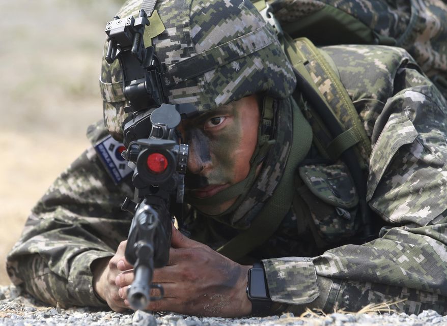A South Korea soldier aims his machine gun during the ongoing Cobra Gold U.S.-Thai joint military exercise on Hat Yao beach in Chonburi province, eastern Thailand, Saturday, Feb. 17, 2018. Approximately 11,000 military personnel from the U.S., Thailand, and South Korea are taking part in the annual drill. (AP Photo/Sakchai Lalit)