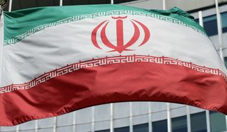 The Iranian flag flies in front of a U.N. building in Vienna, Austria, Friday, July 4, 2014. (AP Photo/Ronald Zak) ** FILE **