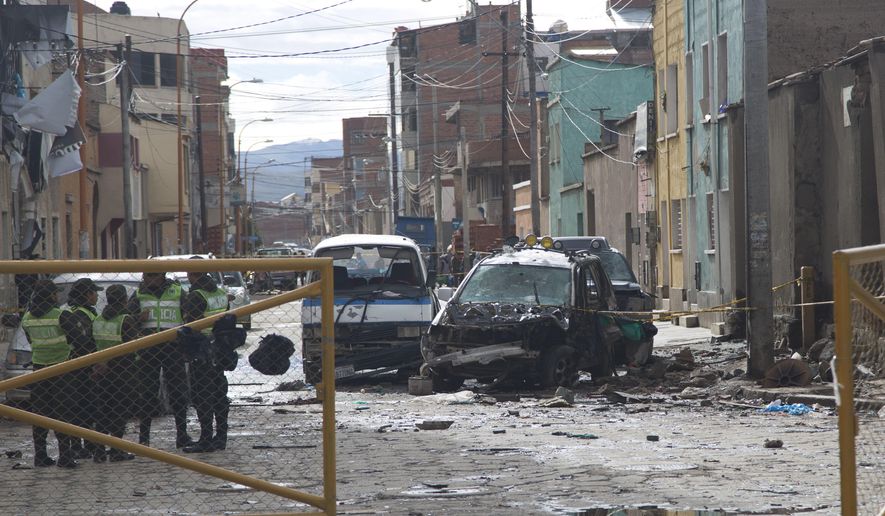 Police stand guard at the site of an explosion in Oruro, Bolivia, Thursday, Feb. 15, 2018. Bolivian officials said Wednesday that a bomb was what caused the explosion that killed four people during Carnival celebrations in Oruro. (AP Photo/Juan Karita)