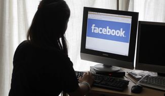 In this June 4, 2012 file photo, a girl looks at Facebook on her computer in Palo Alto, Calif. (AP Photo/Paul Sakuma, File)