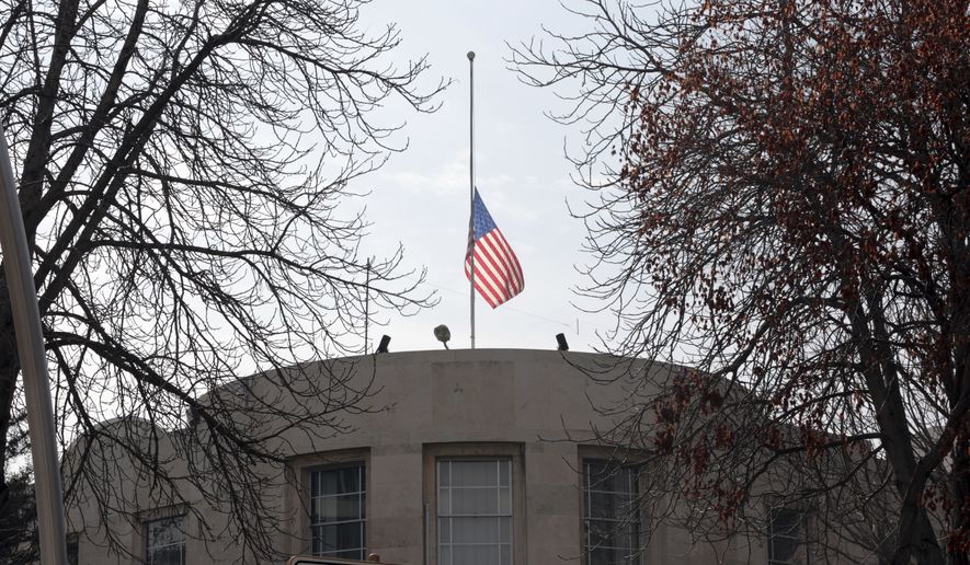 The U.S. Embassy's flag flies at half-mast in respect for the Florida school shooting victims in Ankara, Turkey, Monday, Feb. 19, 2018. Municipality workers on Monday took down the street sign for Nevzat Tandogan Street where the U.S. Embassy is located and replaced it with one that reads "Olive Branch Street." (AP Photo/Burhan Ozbilici)