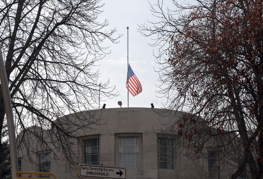 The U.S. Embassy's flag flies at half-mast in respect for the Florida school shooting victims in Ankara, Turkey, Monday, Feb. 19, 2018. Municipality workers on Monday took down the street sign for Nevzat Tandogan Street where the U.S. Embassy is located and replaced it with one that reads "Olive Branch Street." (AP Photo/Burhan Ozbilici)
