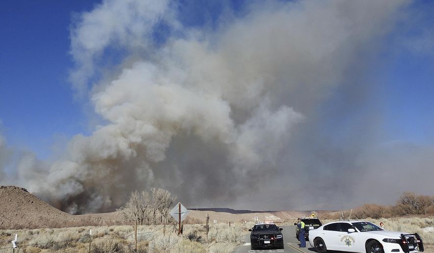 This Sunday, Feb. 18, 2018, photo taken by the Bishop California Highway Patrol and released by the Inyo County Sheriff's Office shows smoke rising from wildfires near Bishop, Calif. A wind-driven wildfire in rural central California forced mandatory evacuations and threatened hundreds of buildings Monday, including a historic railroad station, after it tripled in size overnight, officials said. (Bishop California Highway Patrol via AP)