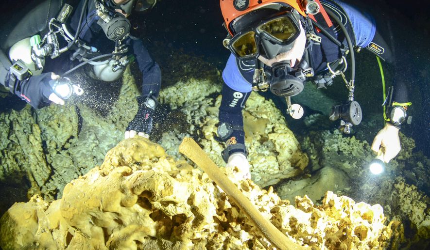 This undated photo released by Mexico's National Anthropology and History Institute (INAH), shows divers from the Great Mayan Aquifer project exploring the Sac Actun underwater cave system where Mayan and Pleistocene bones and cultural artifacts have been found submerged, near Tulum, Mexico. Mexican experts said Monday, Feb. 19, 2018, that the recently mapped Sac Actun cave system "is probably the most important underwater archaeological site in the world," but is threatened by pollution. (Jan Arild Aaserud/Great Mayan Aquifer Project-INAH via AP)