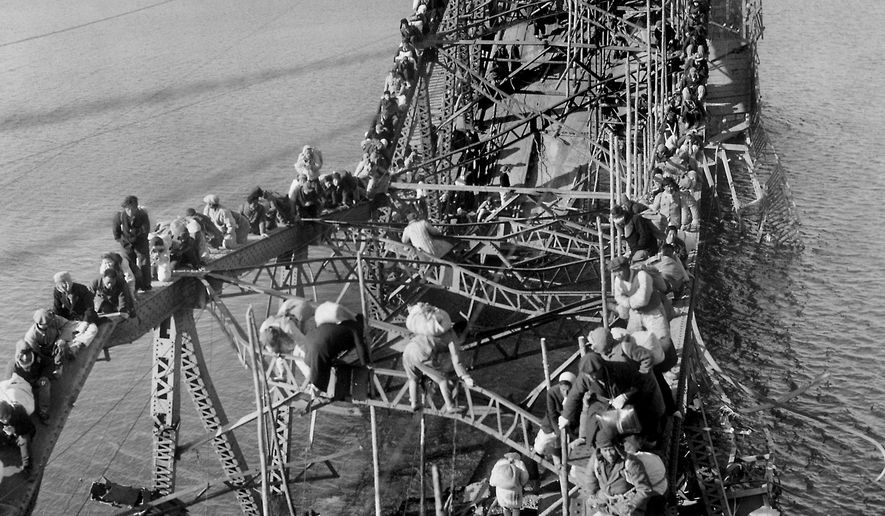 FILE - In this Dec. 4, 1950, file photo, residents from Pyongyang, North Korea, and refugees from other areas crawl perilously over shattered girders of the city's bridge, as they flee south across the Taedong River to escape the advance of Chinese Communist troops. Former Associated Press photographer Max Desfor, whose photo of hundreds of Korean War refugees crawling across a damaged bridge in 1950 helped bring him a Pulitzer Prize, died Monday, Feb. 19, 2018. He was 104. (AP Photo/Max Desfor, File)