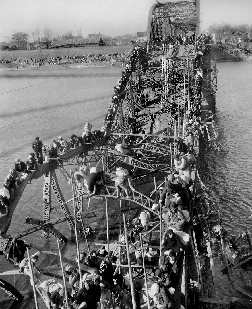 FILE - In this Dec. 4, 1950, file photo, residents from Pyongyang, North Korea, and refugees from other areas crawl perilously over shattered girders of the city's bridge, as they flee south across the Taedong River to escape the advance of Chinese Communist troops. Former Associated Press photographer Max Desfor, whose photo of hundreds of Korean War refugees crawling across a damaged bridge in 1950 helped bring him a Pulitzer Prize, died Monday, Feb. 19, 2018. He was 104. (AP Photo/Max Desfor, File)
