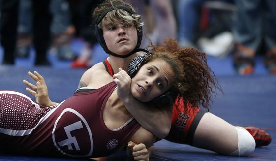 In this Friday, Feb. 16, 2018 photo, Euless Trinity&#x27;s Mack Beggs, top, wrestles Lewisville&#x27;s Elyse Nelson in the second round of the 110-pound girls division during the 6A Region II wrestling meet at Allen High School in Allen, Texas, Beggs, a senior from Euless Trinity High School near Dallas is transgender and in the process of transitioning from female to male. (Jae S. Lee/The Dallas Morning News via AP)