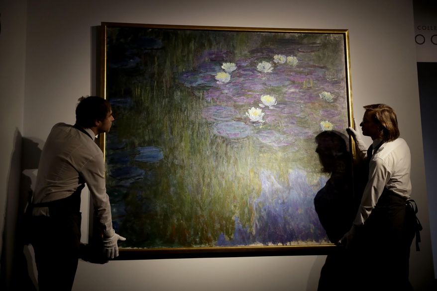 Christie's London auction house staff pose for photographs with Claude Monet's 'Nympheas en fleur', which will feature in the upcoming May 7-11 New York sale of the collection of Peggy and David Rockefeller, at their premises in London, Tuesday, Feb. 20, 2018. The Monet is estimated to fetch $50 million-$70 million (35.7 million to 50 million pounds, 40.5million to 56.7 million euro). The art collection amassed by billionaire David Rockefeller could raise more than $500 million for charity when it is auctioned this spring. (AP Photo/Matt Dunham)